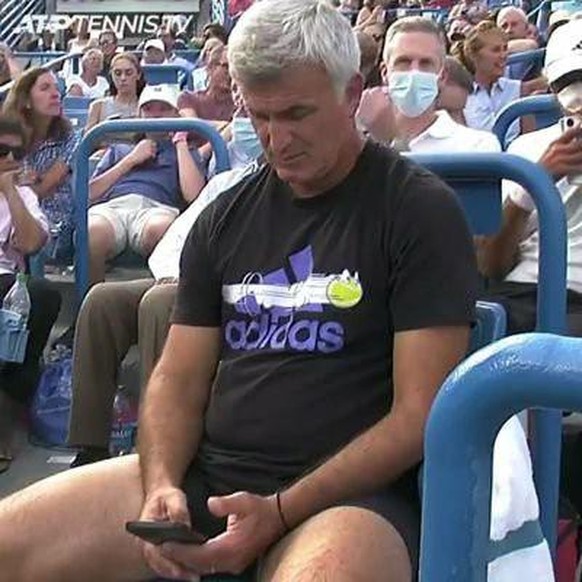 Papa Tsitsipas während der Pause seines Sohnes am Handy.