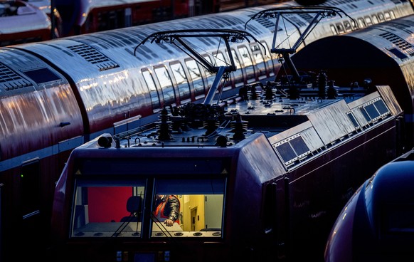 A Deutsche Bahn employee checks a train near the main station in Frankfurt, Germany, Monday, March 27, 2023. Germany faces a nationwide public transport strike on Monday.  (AP Photo/Michael Pre...