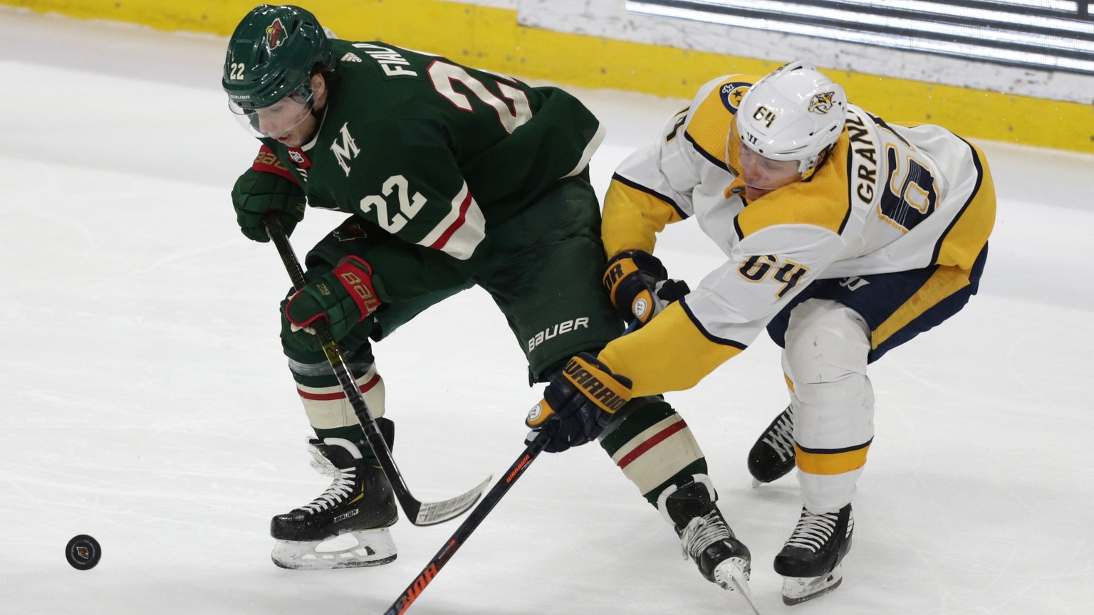 Minnesota Wild left wing Kevin Fiala (22) battles for the puck with Nashville Predators center Mikael Granlund (64) during the third period of an NHL hockey game Tuesday, March 3, 2020, in St. Paul, M ...