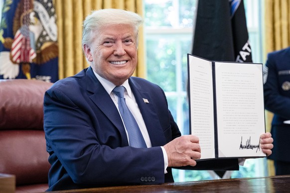 epa08424721 US President Donald J. Trump signs the 2020 Armed Forces Day Proclamation after being presented the official flag of the United States Space Force at the White House in Washington, DC, USA ...