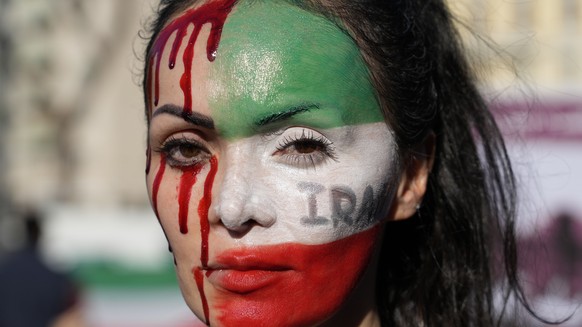 A woman is painted on a her face during a protest against the death of Mahsa Amini, a woman who died while in police custody in Iran, during a rally in central Rome, Saturday, Oct. 29, 2022. (AP Photo ...