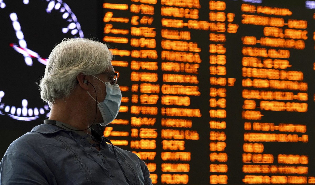 A traveler wears a mask as he waits inside Rome's Termini train station, Tuesday, March 10, 2020. In Italy the government extended a coronavirus containment order previously limited to the countr ...