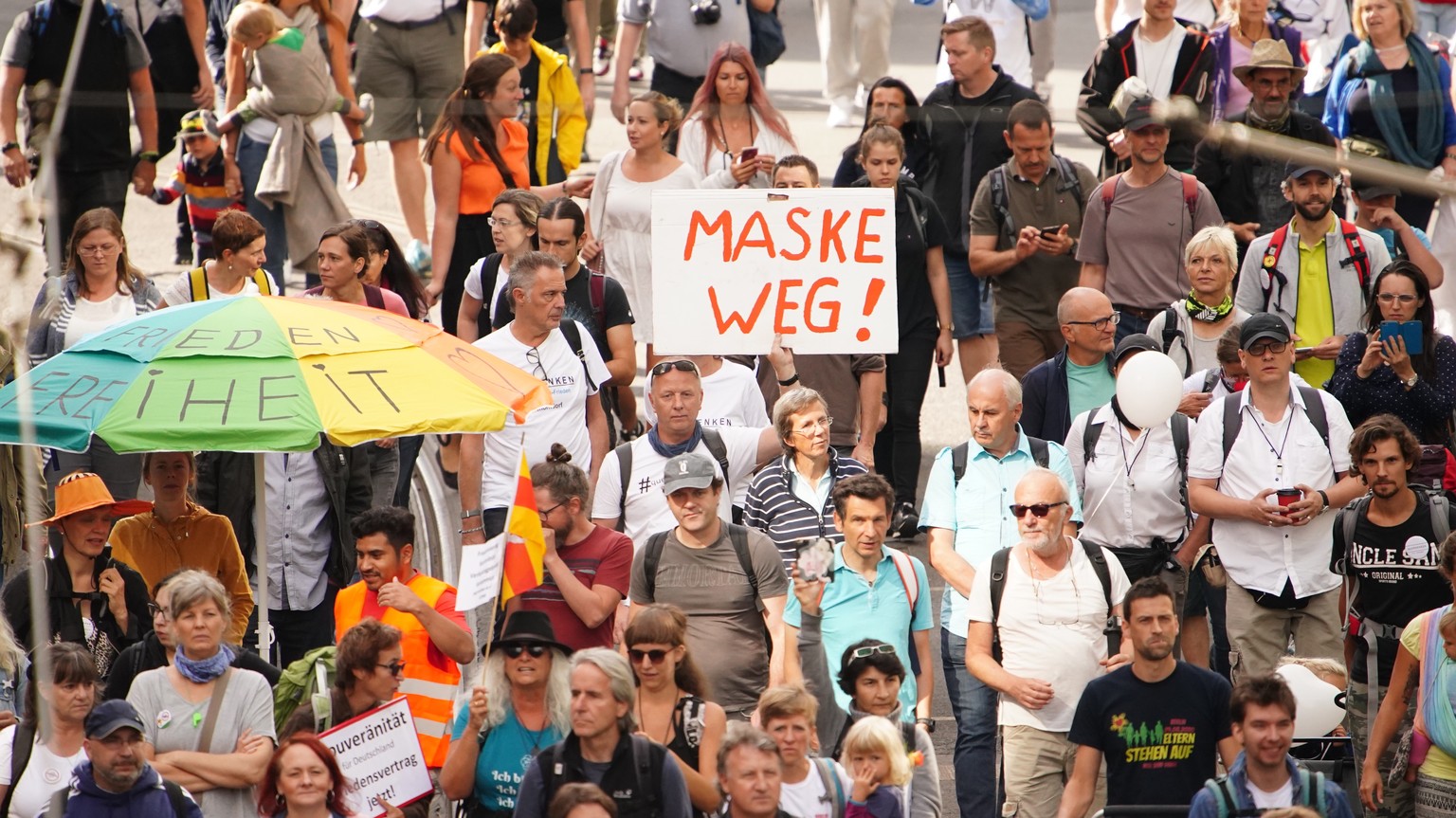 epa08633139 A demonstrator holds a cardboard reading &#039;mask away&#039;, during a protest against coronavirus pandemic regulations in Berlin, Germany, 29 August 2020. The initiative &#039;Querdenke ...