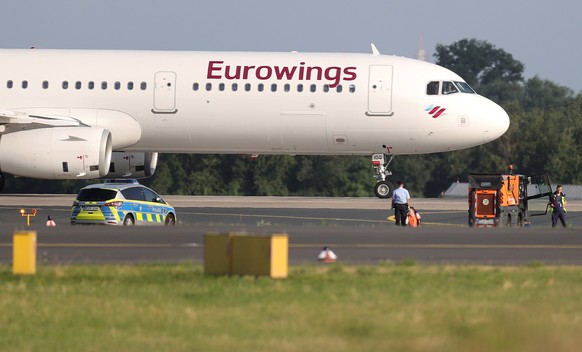 epa10743078 A Letzte Generation (Last Generation) climate activist has his hand glued to the asphalt of the runway at the airport in Duesseldorf, Germany, 13 July 2023. According to the climate activi ...