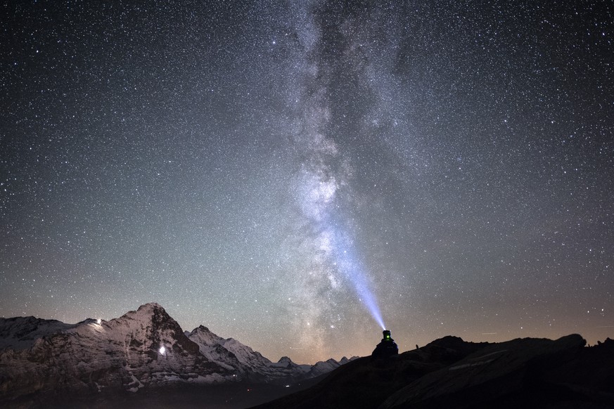 A man looks at the milky way with the Eiger mountain in the background, at First, above Grindelwald in the Bernese Oberland, Switzerland, on Monday, October 3, 2016. (KEYSTONE/Anthony Anex)