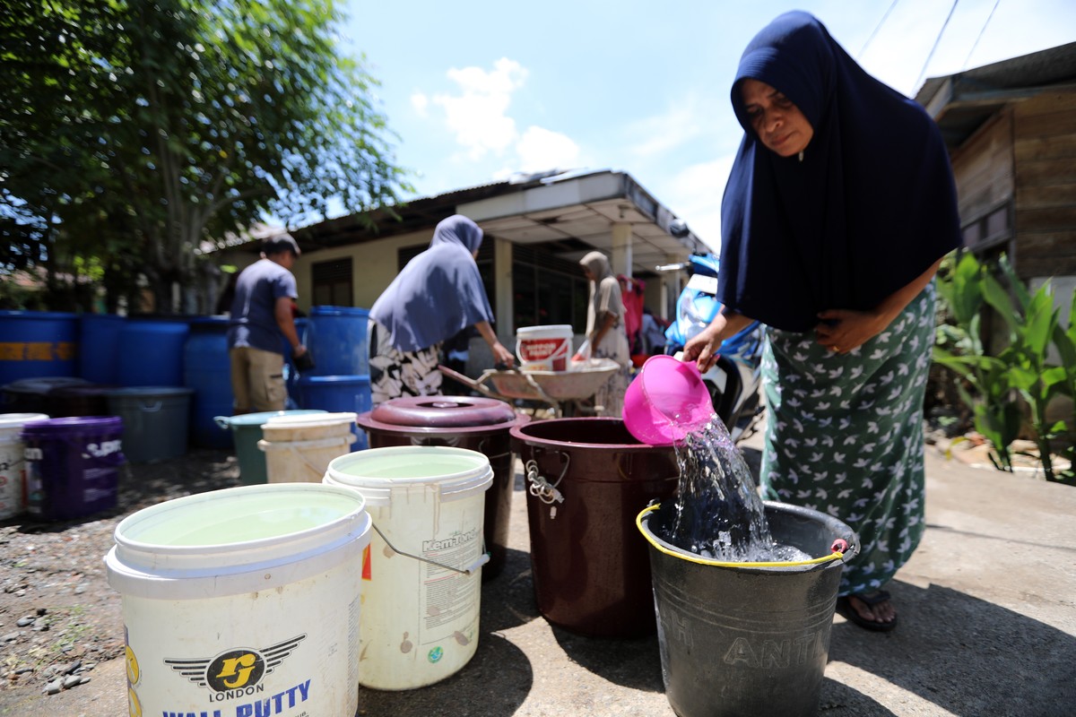 epa11467645 Acehnese women queue to get clean water from a water tank provided by the government in an area experiencing drought due to the dry season, in Lamcok, Aceh Besar, Indonesia, 09 July 2024.  ...