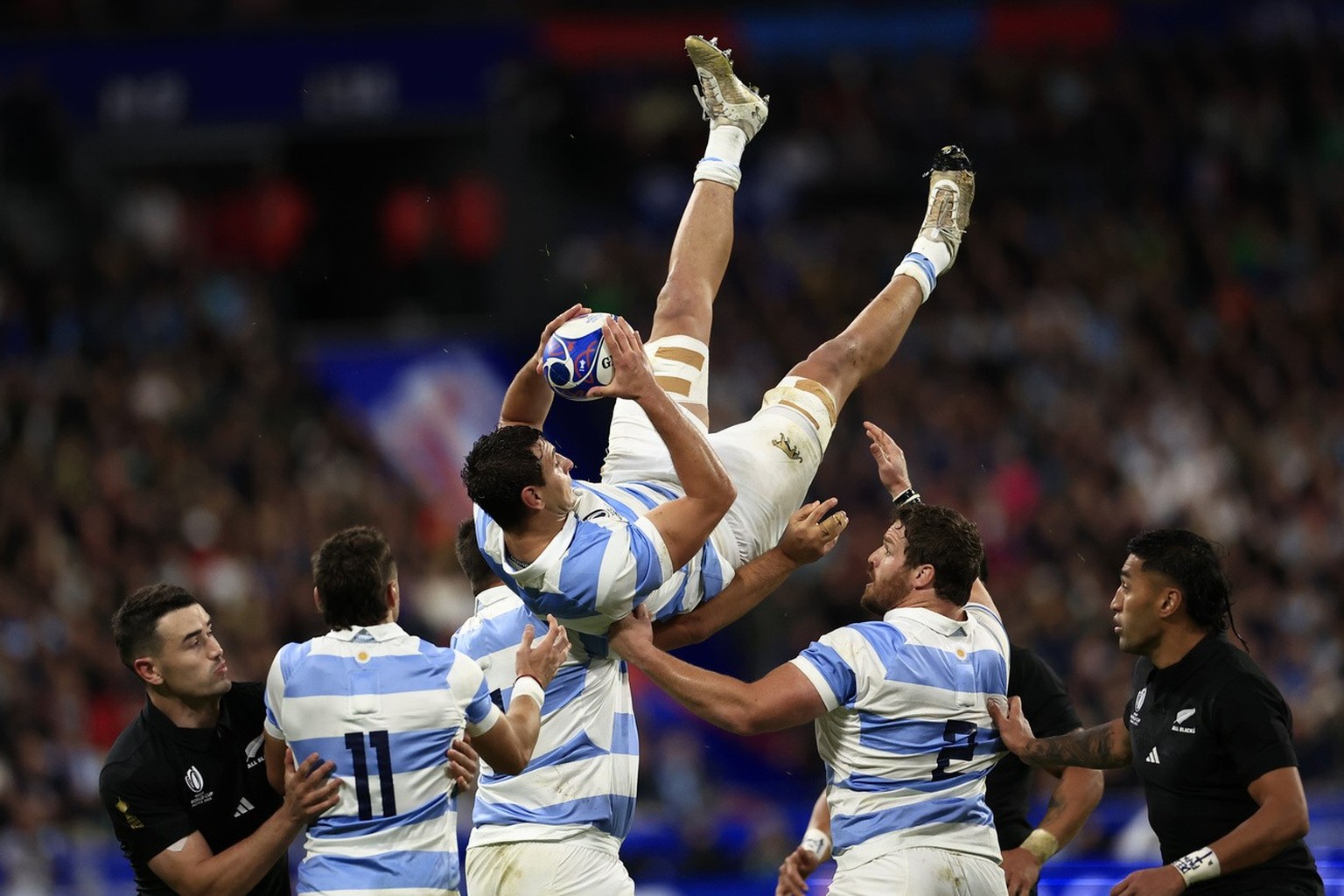 Argentina's Juan Martin Gonzalez, top, catches the ball during the Rugby World Cup semifinal match between Argentina and New Zealand at the Stade de France in Saint-Denis, outside Paris, Friday, ...