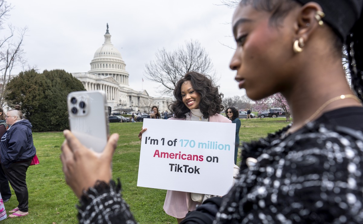 FILE - Devotees of TikTok, Mona Swain, center, and her sister, Rachel Swain, right, both of Atlanta, monitor voting at the Capitol in Washington, as the House passed a bill that would lead to a nation ...