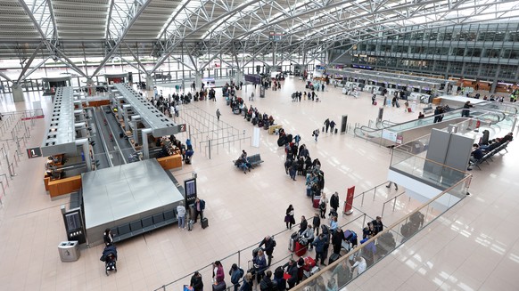 31.01.2024, Hamburg: Reisende stehen in einer Schlange an Check-In-Schaltern im Terminal 1 am Hamburger Flughafen an. Die Gewerkschaft Verdi hat Besch