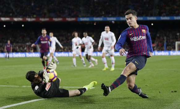 FC Barcelona&#039;s Coutinho, right, kicks the ball as Eibar&#039;s goalkeeper Asier Riesgo saves a ball during the Spanish La Liga soccer match between FC Barcelona and Eibar at the Camp Nou stadium  ...