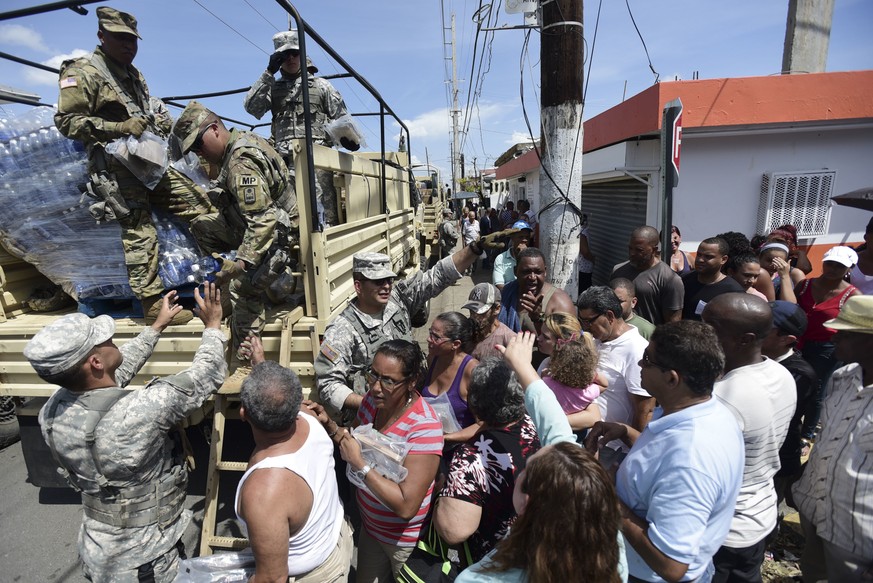 National Guardsmen arrive at Barrio Obrero in Santurce to distribute water and food among those affected by the passage of Hurricane Maria, in San Juan, Puerto Rico, Sunday, Sept. 24, 2017. Puerto Ric ...