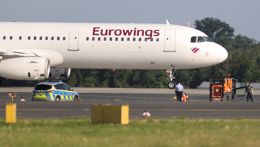 epa10743078 A Last Generation climate activist has his hand glued to the asphalt of the airport runway in Dusseldorf, Germany, July 13, 2023. According to the climate activists...