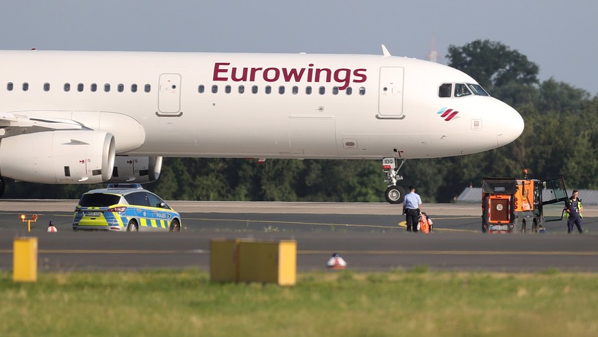 epa10743078 A Letzte Generation (Last Generation) climate activist has his hand glued to the asphalt of the runway at the airport in Duesseldorf, Germany, 13 July 2023. According to the climate activi ...