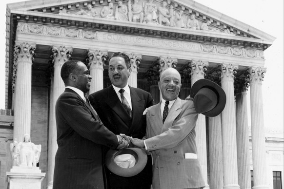 FILE - This May 17, 1954, file photo shows, from left, George E.C. Hayes, Thurgood Marshall, and James M. Nabrit joining hands as they pose outside the Supreme Court in Washington. The three lawyers l ...