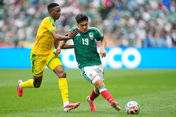South Africa's Thalente Mbatha, left, vies for the ball with Mexico's Gilberto Mora during the World Cup Group A soccer match between Mexico and South Africa in Mexico City, Thursday, June 1 ...