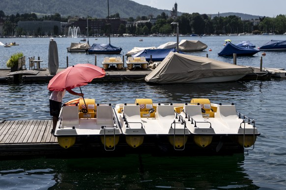 Ein Mann praepariert ein Pedalo mit einem Sonnenschirm bei sommerlichem Wetter mit Temperaturen ueber 30 Grad am Mittwoch, 27. Mai 2026 am Zuerichhorn in Zuerich. (KEYSTONE/Claudio Thoma)