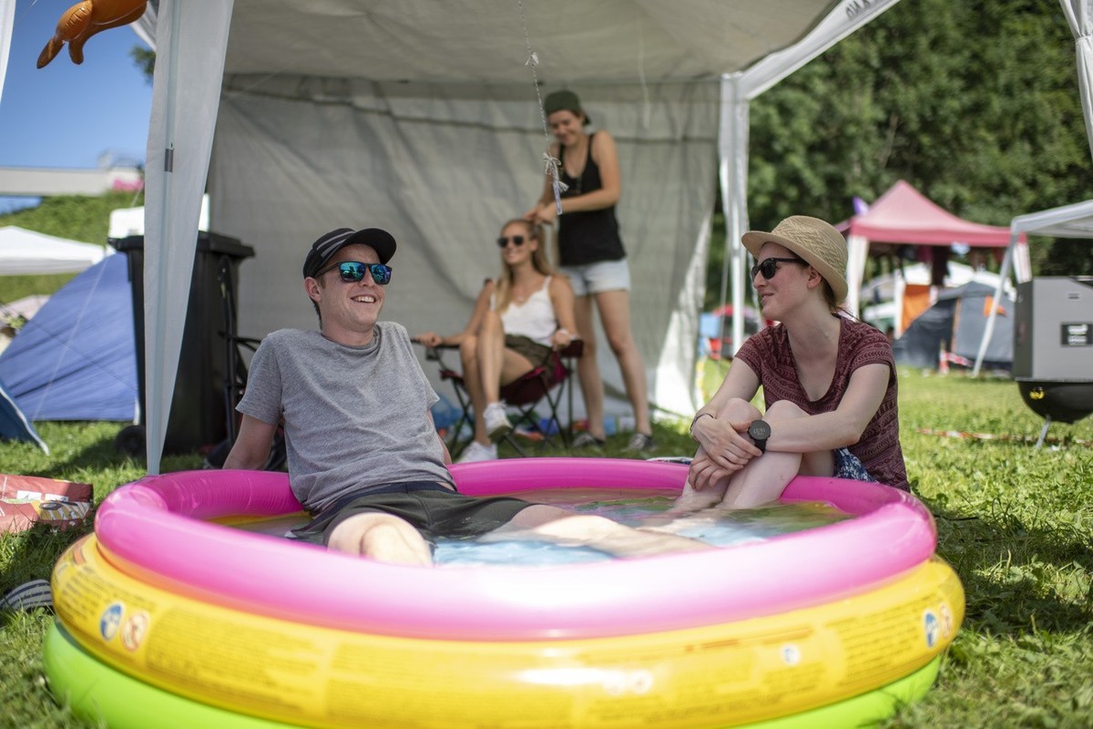 Visitors take a bath on the second day of the 43. St. Gallen Openair, on Friday, June 28, 2019, in St. Gallen, Switzerland. The music festival takes place from June 27 to 30. (KEYSTONE/Gian Ehrenzelle ...