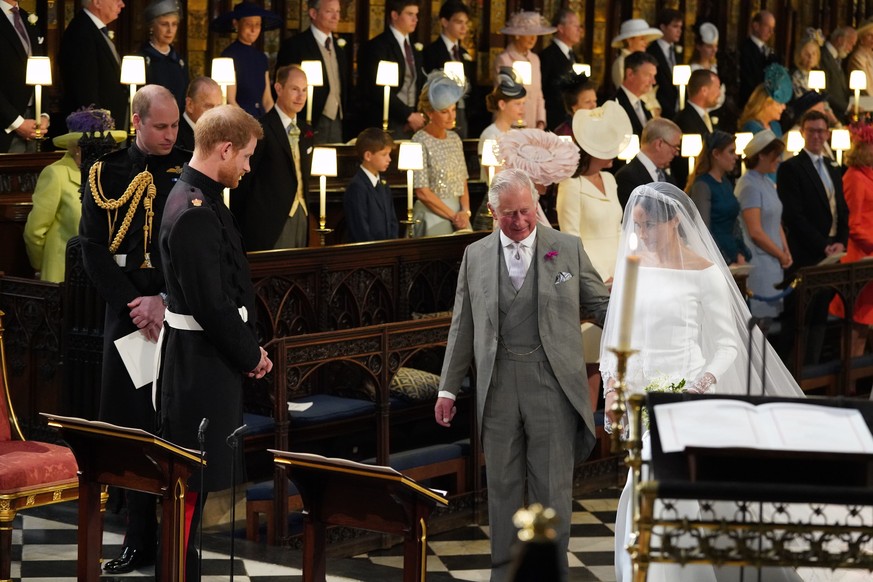 Britain&#039;s Prince Harry looks at his bride, Meghan Markle, as she arrives accompanied by the Prince Charles during the wedding ceremony of Prince Harry and Meghan Markle at St. George&#039;s Chape ...