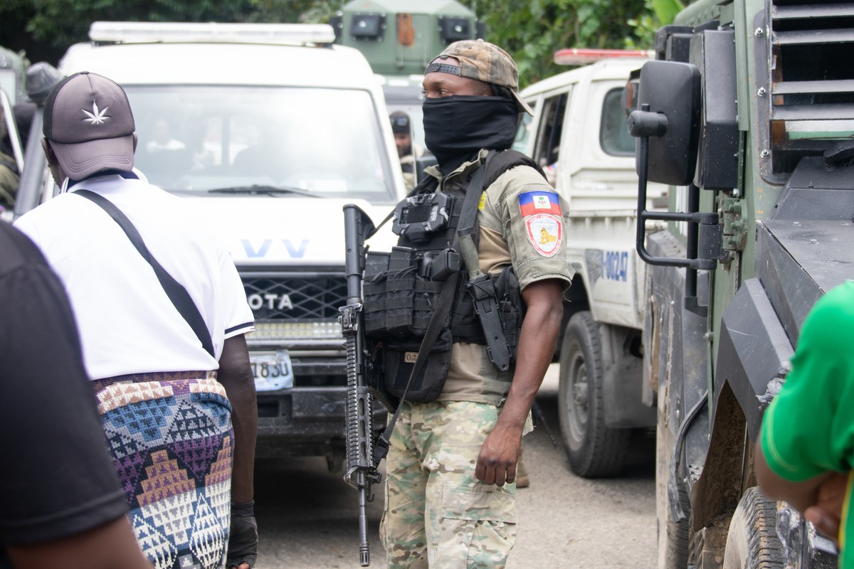 epa13189711 A member of the Haitian Armed Forces stands guard on a street after an armed attack in the Kenscoff area, Haiti, 24 August 2026. Between 30 and 40 people were killed in an overnight gang a ...