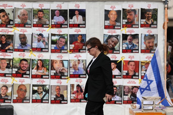 epaselect epa11830531 A woman walks past a display of posters calling for the release of Israeli hostages, who were abducted by militants during the 07 October 2023 Hamas attacks, outside the Kirya mi ...