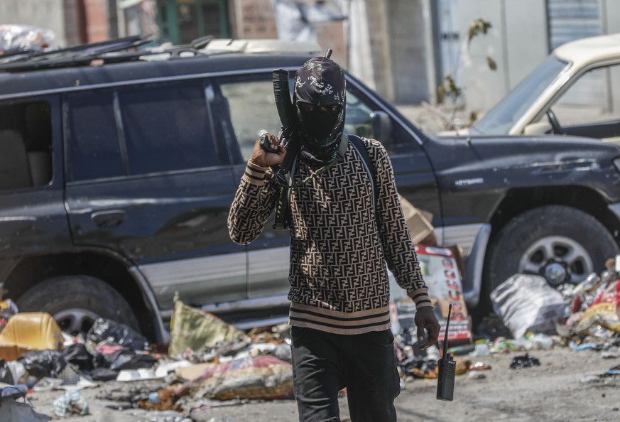 An armed member of the G9 and Family gang patrols a roadblock in the Delmas 6 neighborhood of Port-au-Prince, Haiti, Monday, March 11, 2024. (AP Photo/Odelyn Joseph)