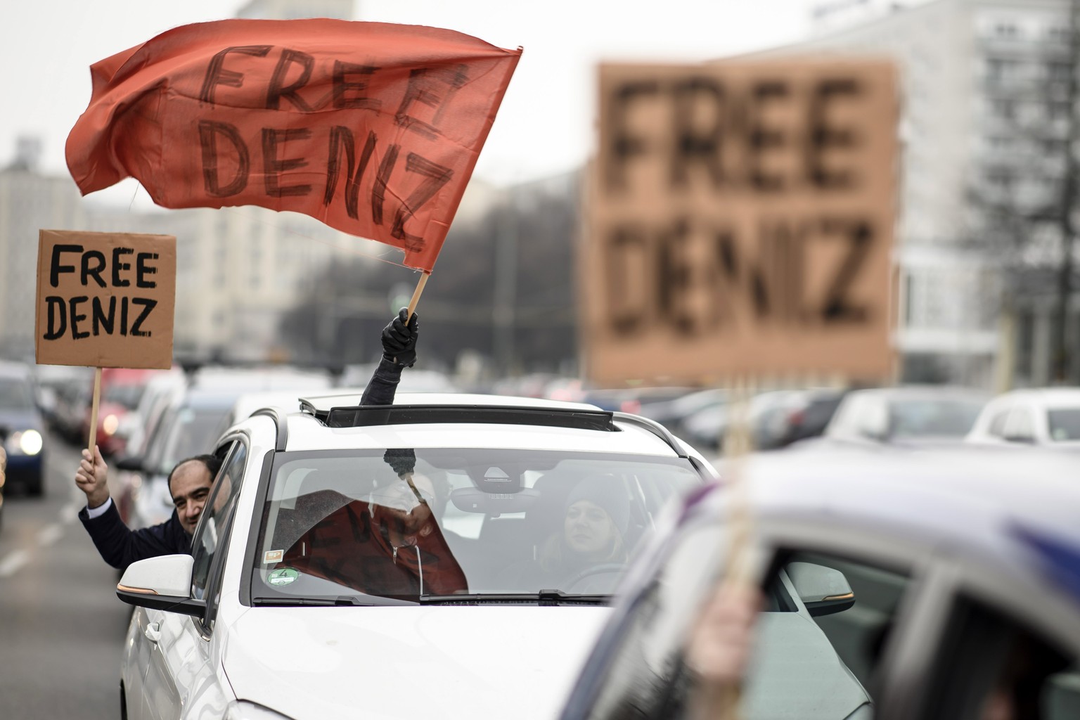 epa05804070 Protestors, among them German member of parliament Ozcan Mutlu (Greens Party, L) wave flags and hold pieces of paper or cardboard reading &#039;Free Deniz&#039; during a motorcade on the o ...