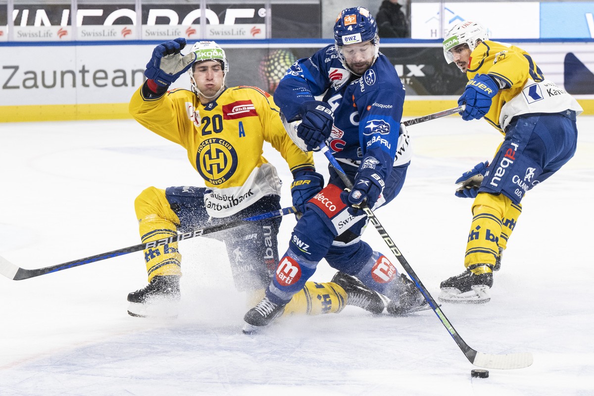 Davos' Michael Fora, links, kaempft um den Puck gegen Zuerichs Patrick Geering, rechts, im Eishockeyspiel der National League zwischen den ZSC Lions und dem HC Davos am Samstag, 19. November 2022 ...