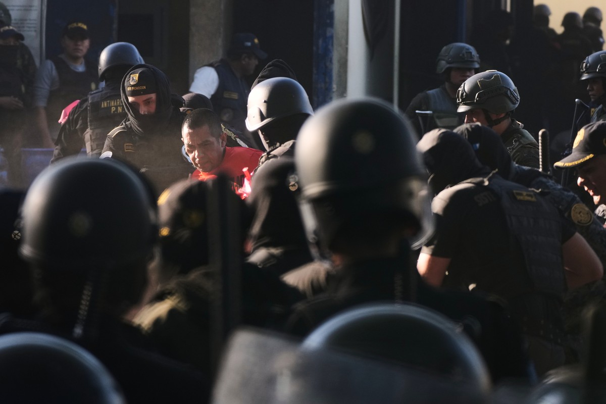 Security forces escort an inmate after entering the Renovacion maximum-security prison to free guards taken hostage and retake control of the facility, which houses gang leaders, in Escuintla, Guatema ...