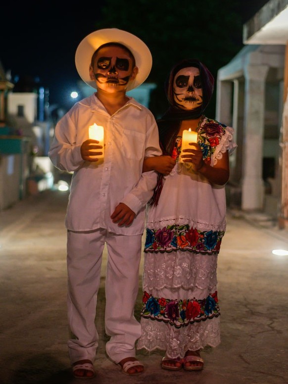 PROGRESO, MEXICO - NOVEMBER 1: Persons dressed with colorful regional clothing and faces painted as skulls take part during the &#039;Walk of the Souls&#039; as part of Mexico&#039;s Day of the Dead ( ...