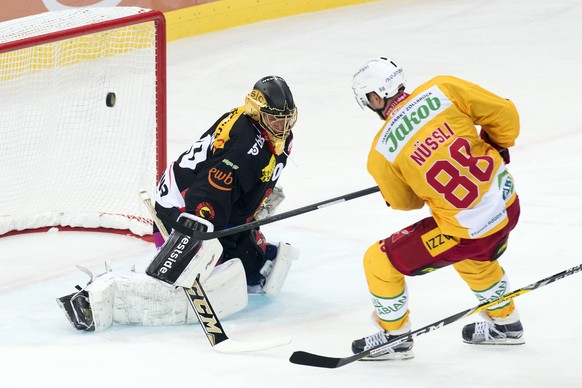 SC Bern Torhueter Leonardo Genoni, links, und SCL Tigers Stuermer Thomas Nuessli, rechts, kaempfen um den Puck, beim Eishockey Meisterschaftsspiel der NLA zwischen dem SC Bern den SCL Tigers und am Fr ...