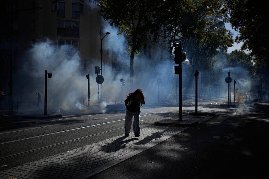 KEYPIX - A student runs out the teargas during a protest against under-resourced schools in Lyon, France, Friday, Oct. 2, 2026. (KEYSTONE/AP Photo/Laurent Cipriani)