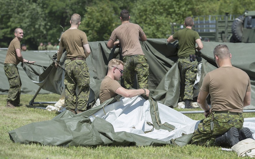 Members of the Canadian armed forces erect tents to house asylum seekers at the Canada-United States border in Lacolle, Quebec, Wednesday, Aug. 9, 2017. (Graham Hughes/The Canadian Press via AP)