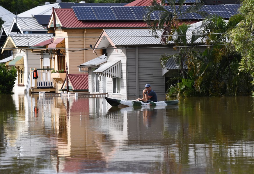 epa09790484 A man is seen paddling a kayak through flood waters covering Torwood Street in the suburb of Milton in Brisbane, Australia, 28 February 2022. Queensland&#039;s southeast is set to endure m ...