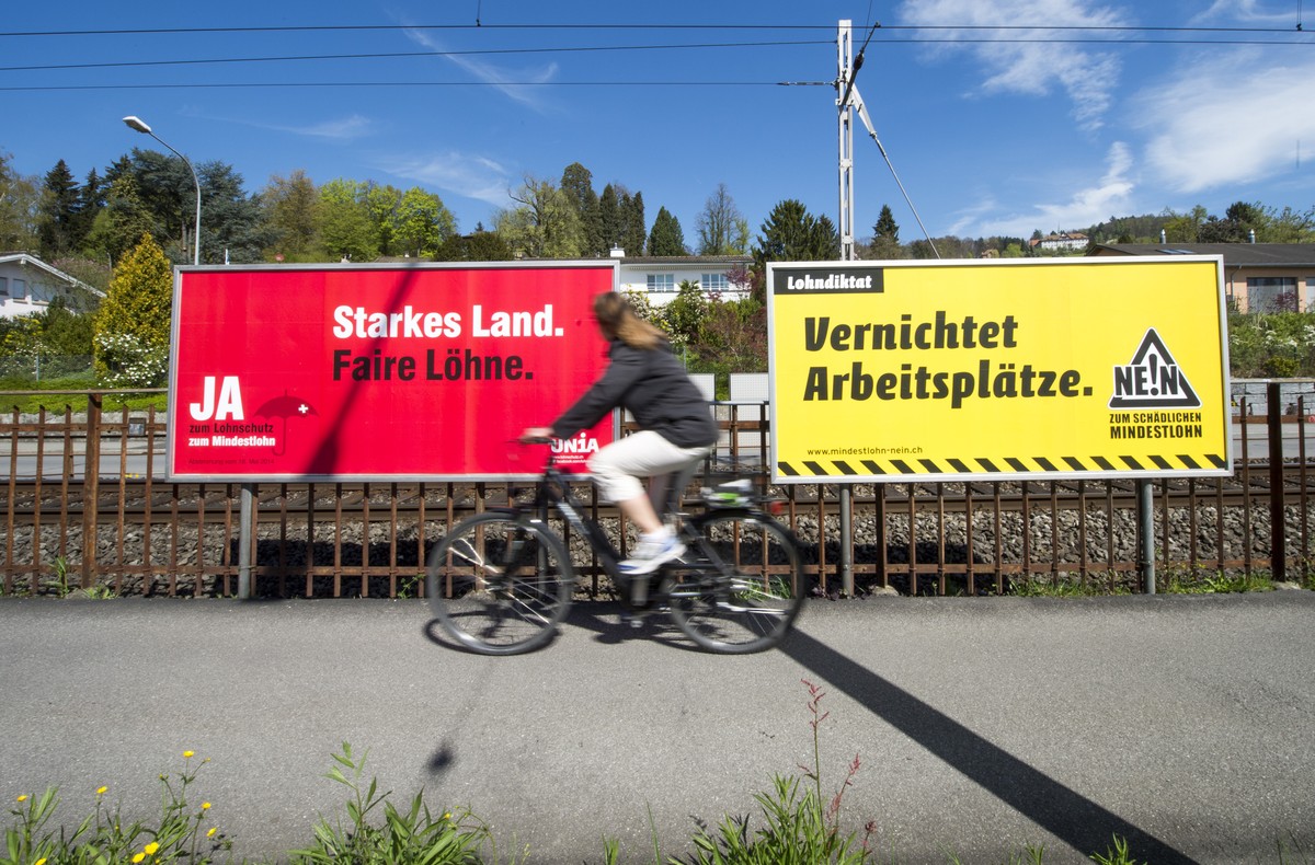 Plakate von Befuerwortern und Gegnern der Volksinitiative "Fuer den Schutz fairer Loehne (Mindestlohn-Initiative)", welche am 18. Mai 2014 zur Volksabstimmung kommt, stehen am Freitag, 11. A ...