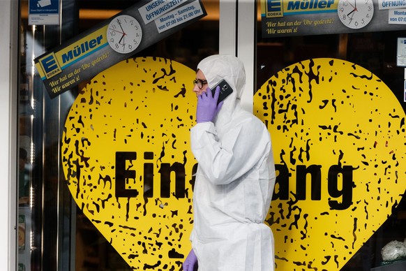 Ein Polizeibeamter der Spurensicherung in einem Schutzanzug geht am 28.07.2017 in Hamburg vor einem Supermarkt, in dem am Nachmittag ein Mann eine Person toetete und vier Verletzte. Der mutmassliche T ...