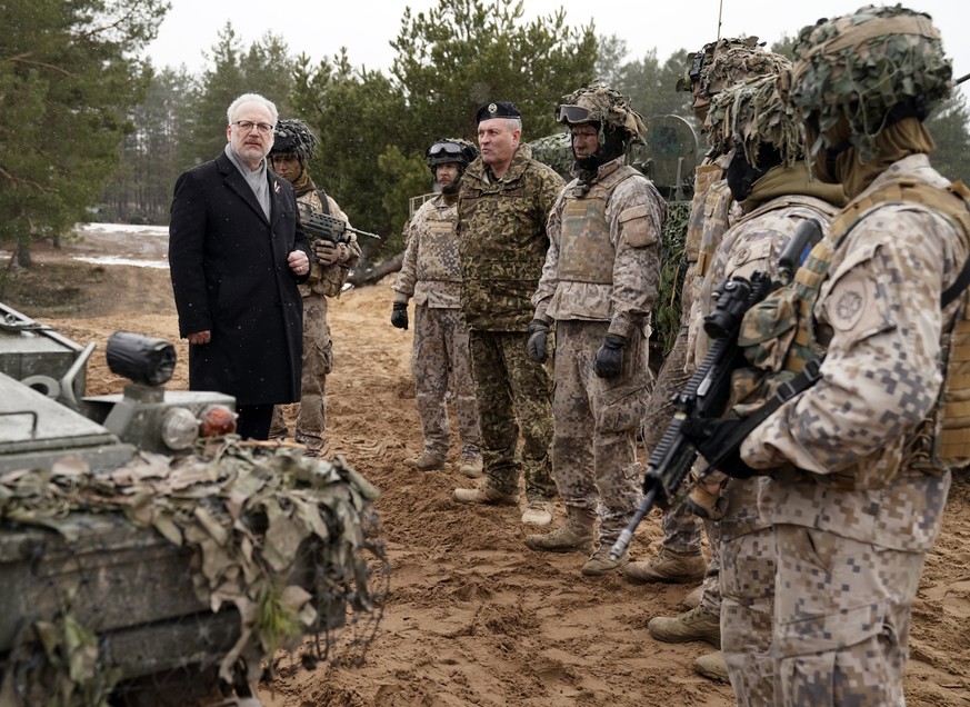 Latvian President Egils Levits speaks to Latvian troops during his visit to Adazi Military base in Kadaga, Latvia, Tuesday, March. 8, 2022. (AP Photo/Roman Koksarov)