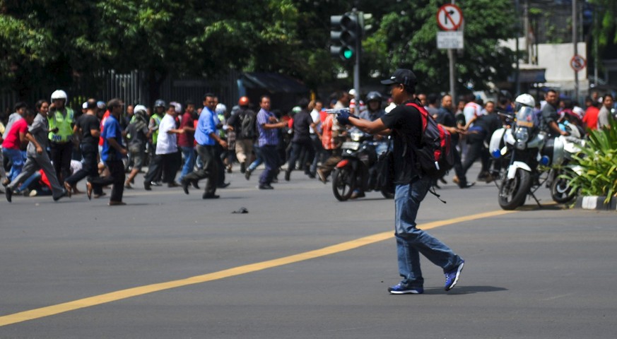 Ein Angreifer zielt im Zentrum Jakartas mit einer Pistole in die Menge.