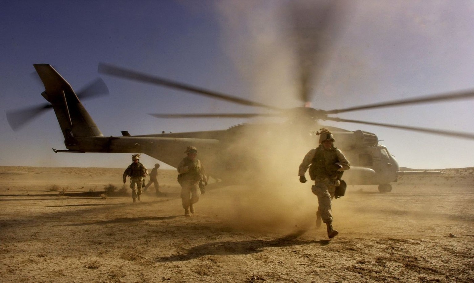 U.S. Marines run to load their gear as they prepare to fly to a new position somewhere near Kandahar, Afghanistan, Monday, Dec. 10, 2001. U.S. Marines moved troops and heavy weapons closer to the fall ...