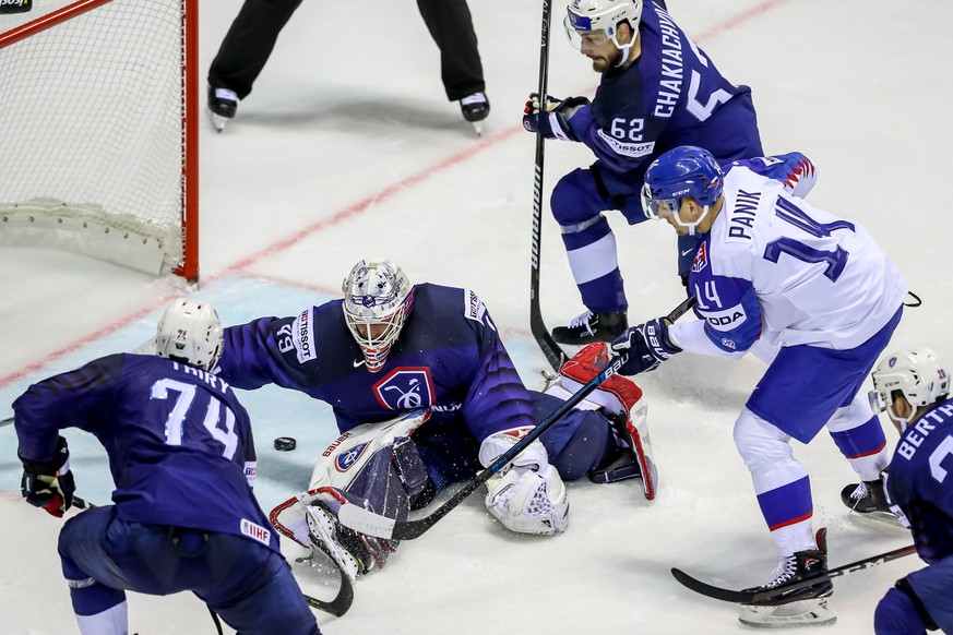 epa07578954 Richard Panik of Slovakia (R) in action against goalkeeper Florian Hardy of France (C) during the IIHF World Championship group A ice hockey match between France and Slovakia at the Steel  ...