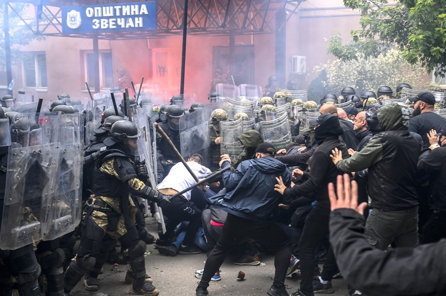 epa10662195 Soldiers of NATO-led international peacekeeping Kosovo Force (KFOR) clash with ethnic Serbs in front of the building of the municipality in Zvecan, Kosovo, 29 May 2023. Protests and clashe ...