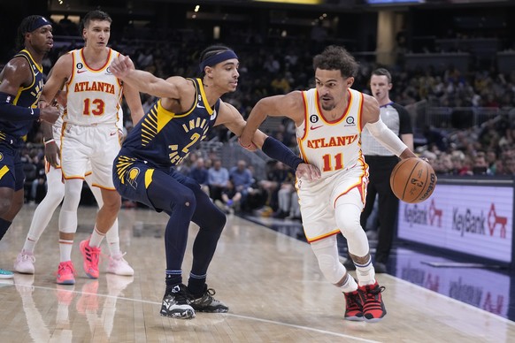Atlanta Hawks' Trae Young (11) drives against Indiana Pacers' Andrew Nembhard (2) during the first half of an NBA basketball game Tuesday, Dec. 27, 2022, in Indianapolis. (AP Photo/Darron Cummings)