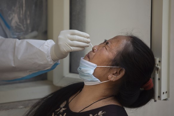 A health worker takes a nasal swab sample at a COVID-19 testing center in New Delhi, India, Thursday, Oct. 29, 2020. India's confirmed coronavirus caseload surpassed 8 million on Thursday with daily infections dipping to the lowest level this week, as concerns grew over a major Hindu festival season and winter setting in. (AP Photo/Altaf Qadri)