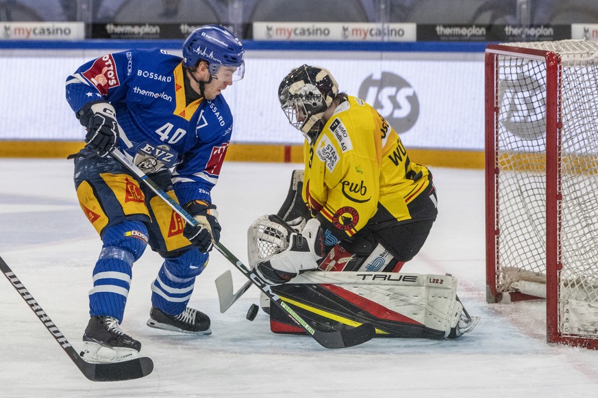 Andreas Wingerli, links, von Zug im Spiel gegen Torhueter Philip Wuethrich, rechts, von Bern beim Eishockey Meisterschaftsspiel der National League zwischen dem EV Zug und dem SC Bern am Freitag, 23.  ...