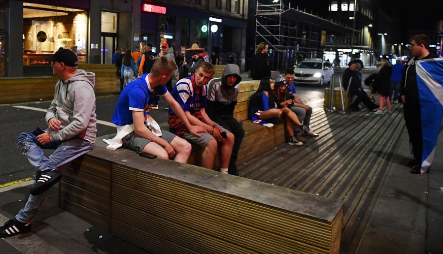 epa09956595 Dejected Rangers fans in Glasgow after their team lost the UEFA Europa League final between Eintracht Frankfurt and Glasgow Rangers in Glasgow, Britain, 18 May 2022. The final between the  ...