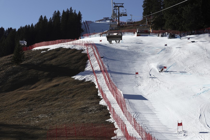 FILE - An athlete speeds down the course during an alpine ski, men&#039;s World Cup giant slalom race, in Adelboden, Switzerland, Saturday, Jan. 7, 2023. Mother Nature and global warming are having ju ...