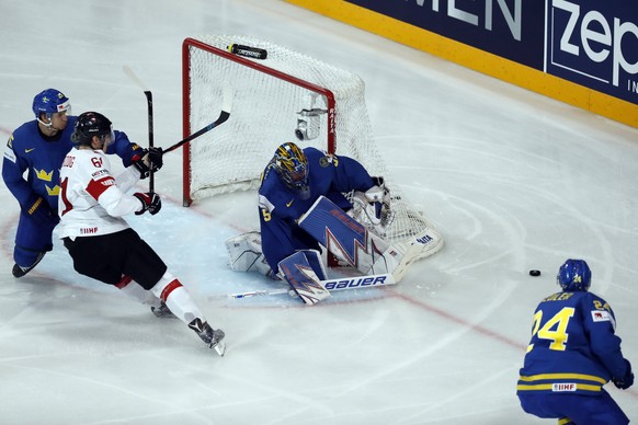 epa05972826 Henrik Lundqvist of Sweden (C) in action against Fabrice Herzog of Switzerland during the IIHF Ice Hockey World Championship 2017 quarter final game between Switzerland and Sweden in Paris ...