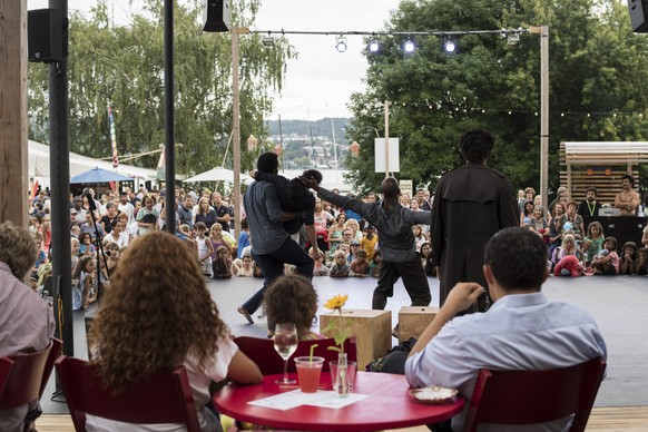 Besucher des Theaterspektakels verfolgen die Vorfuehrung eines Strassenkuenstlers am Freitag, 19. August 2016 auf der Landiwiese in Zuerich. Das Zuercher Theater Spektakel dauert vom 18. August bis zu ...