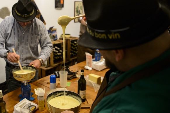 Des participants preparent une fondue pendant la phase qualificative lors du 1er Mondial de fondue, le premier concours au monde de preparation de fondue ce samedi 21 novembre 2015 a Tartegnin dans le ...