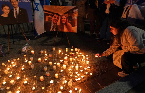 People gather to light candles in a makeshift memorial to honor Yaron Lischinsky and Sarah Milgrim who were killed as they left an event at the Capital Jewish Museum in Washington, during a candleligh ...