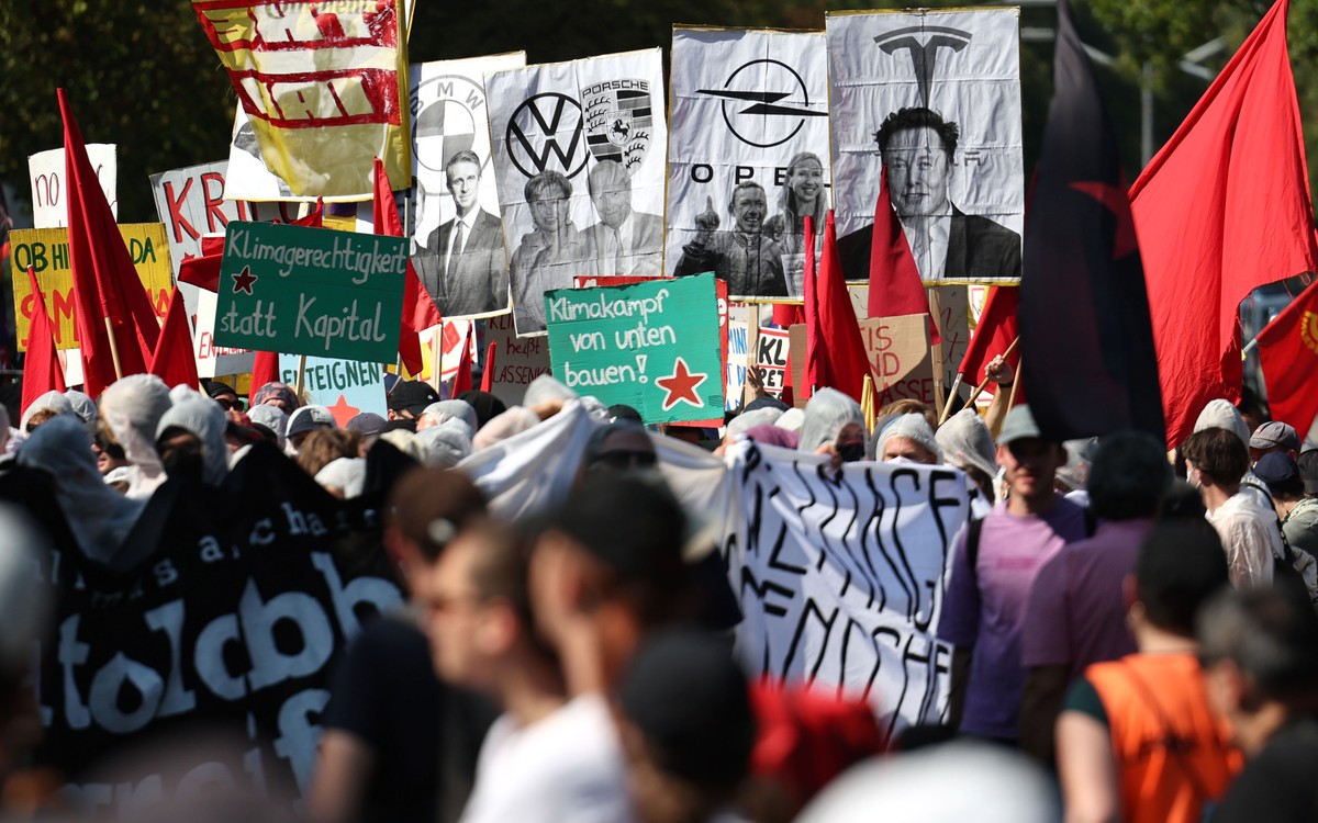 epa10852526 Demonstrators hold banners with the logo of Tesla and the face of its CEO, Elon Musk, to protest against the International Motor Show (IAA) in Munich, Germany, 10 September 2023. The 2023  ...